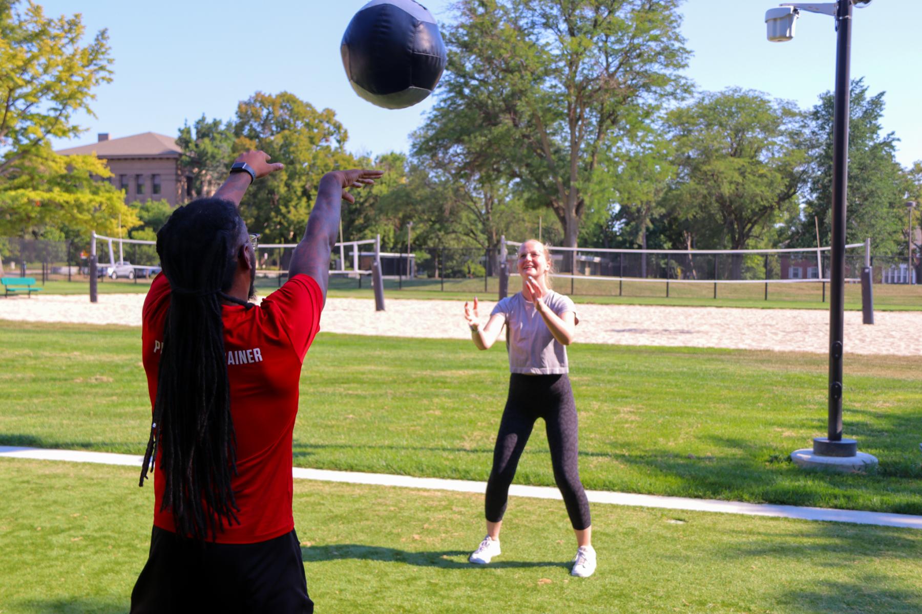 Participants work out with a medicine ball at the Fitbox on East Campus